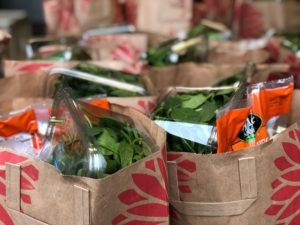 Paper grocery store bags filled with food from Community Food Bank of San Benito County