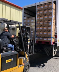 Food bank assets, pallets of foods off-loaded from truck with forklift